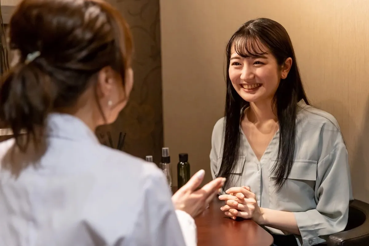 笑顔で話し合う二人の女性。温かい雰囲気と、リラックスした会話が感じられます。